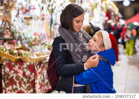 Happy tween boy with mom during shopping at Christmas fair 109037317