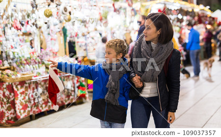 Happy woman with preteen son walking at Christmas fair 109037357