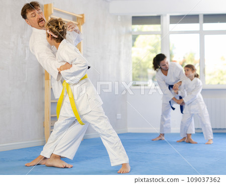 Parent with child athletes in pair conduct training battle in oriental fighting technique 109037362