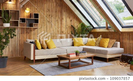 閣樓上的現代客廳配有轉角沙發和質樸的桌子，木牆上配有書架。 AI生成影像 109037857