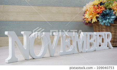 November alphabet letters and flower with space for copy on wooden background 109040753