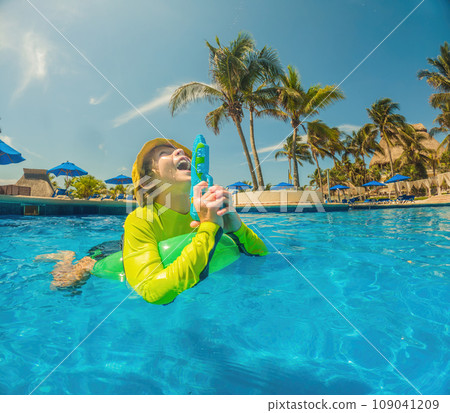 boy fun jumping into the swimming pool, shot through the underwater package 109041209