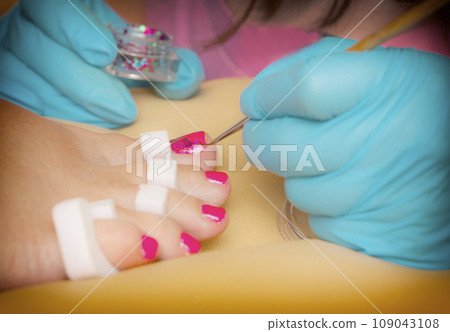 Master does a pedicure in a beauty salon. Close up. 109043108