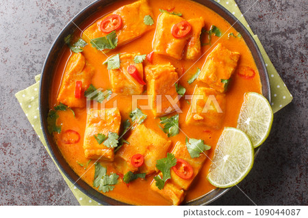 Asian spicy coconut tomato fish curry closeup on a plate. Horizontal top view 109044087