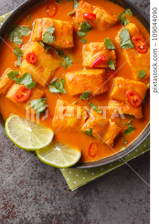 Sri Lanka coconut tomato fish curry close up on a plate. Vertical top view Sri Lanka coconut tomato fish curry close up on a plate. Vertical top view 109044090