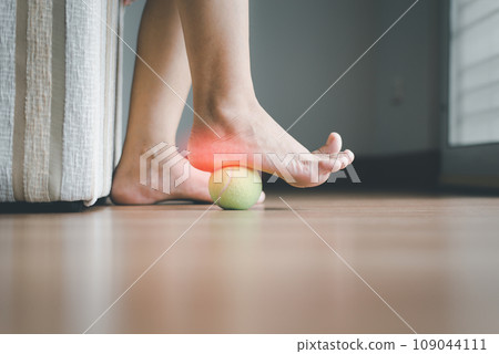 Woman massaging with tennis ball on foot,Feet soles massage for plantar fasciitis 109044111
