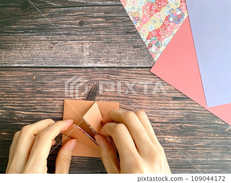 Hands of a woman doing origami Hands of a woman doing origami 109044172