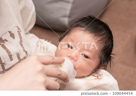 [Newborn baby breastfeeding with a bottle] 109044454