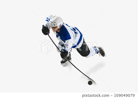 Top view. Competitive young man, hockey player in motion, playing, training on rink against white studio background Top view. Competitive young man, hockey player in motion, playing, training on rink against white studio background 109049079