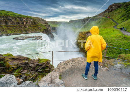 Female tourist enjoying on viewpoint of Gullfoss waterfall with hvita river flowing in canyon at Iceland Female tourist enjoying on viewpoint of Gullfoss waterfall with hvita river flowing in canyon at Iceland 109050517
