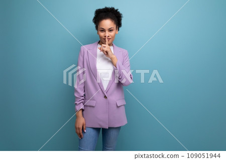 young smart hispanic business woman with curly hair in a lilac jacket keeps a secret 109051944