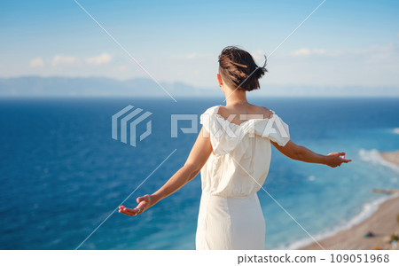 Beautiful Asian young woman in white dress outdoor in flower field under Rhodes city and above sea during sunset. embracing fresh air and engaging in outdoor activities. strong wind - element of Beautiful Asian young woman in white dress outdoor in flower field under Rhodes city and above sea during sunset. embracing fresh air and engaging in outdoor activities. strong wind - element of 109051968