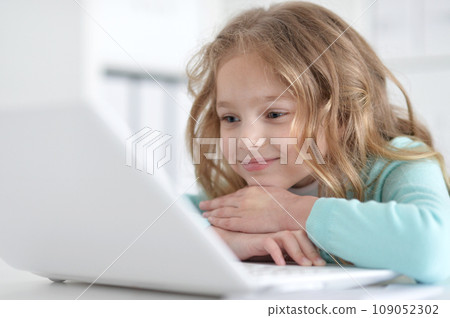 Cute and happy little girl children using laptop computer Cute and happy little girl children using laptop computer 109052302
