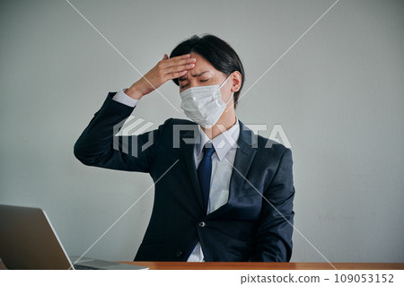 A young male office worker who has a headache and puts his hand on his forehead A young male office worker who has a headache and puts his hand on his forehead 109053152