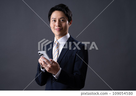 Middle-aged businessman looking at smartphone Middle-aged businessman looking at smartphone 109054580