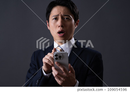 看智慧型手機的中年商人 109054596