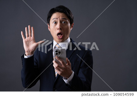 Middle-aged businessman looking at smartphone Middle-aged businessman looking at smartphone 109054599