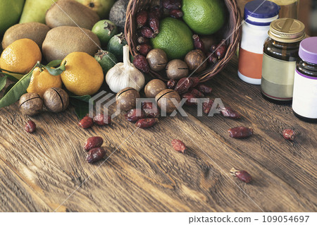 Set of fresh fruits, nuts and jars of supplements on wooden surface, close-up. Set of fresh fruits, nuts and jars of supplements on wooden surface, close-up. 109054697