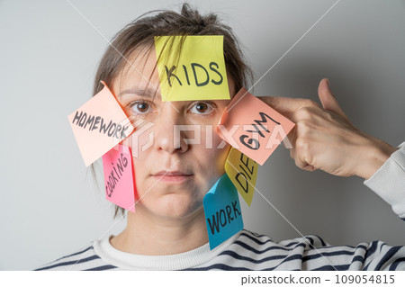 Mental load concept - female has post-it notes with social responcibilities on her face 109054815