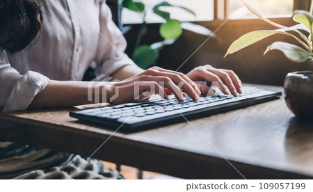 Close-up of woman's hands typing on bluetooth keyboard Close-up of woman's hands typing on bluetooth keyboard 109057199