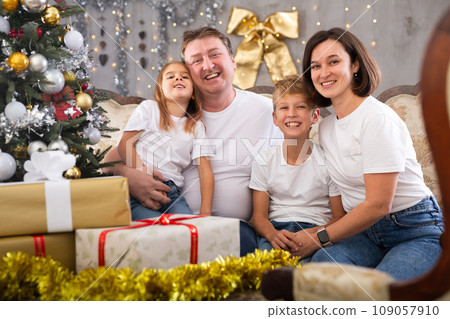 Portrait of parents with son and daughter during christmas celebration at home Portrait of parents with son and daughter during christmas celebration at home 109057910