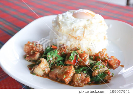 stir fried pork with basil and rice , sunny side up egg or stir fried bacon with basil 109057941