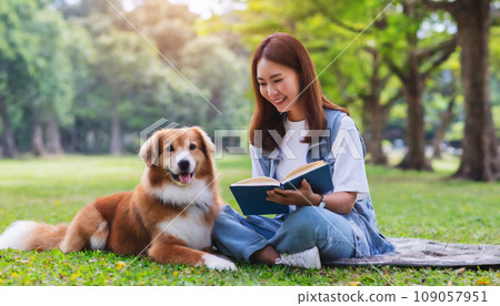Young woman reading a book with her dog in the park AI-generated image 109057951