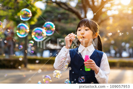 Girls playing with soap bubbles 109057953