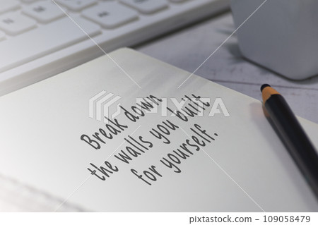 Motivational quote on notepad - Break down the walls you built for yourself. 109058479