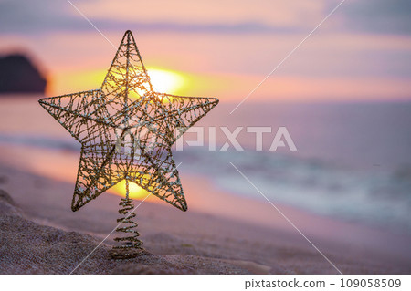 Golden christmas tree toy with big star on the beach 109058509