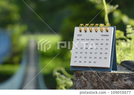 October 2024 calendar with green blurred background of hanging bridge. October 2024 calendar with green blurred background of hanging bridge. 109058877