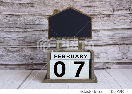 Chalkboard with date on white cube block on wooden table. 109059034