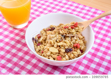 Cereal on pink plaid placemat, fruit granola, breakfast, health food Cereal on pink plaid placemat, fruit granola, breakfast, health food 109059785