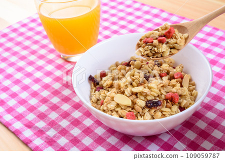 Cereal on pink plaid placemat, fruit granola, breakfast, health food Cereal on pink plaid placemat, fruit granola, breakfast, health food 109059787
