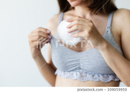 Woman putting in bra the absorbent pad. Selective focus. 109059950