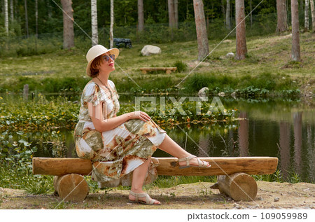Woman relaxes on lakeshore in summer morning 109059989