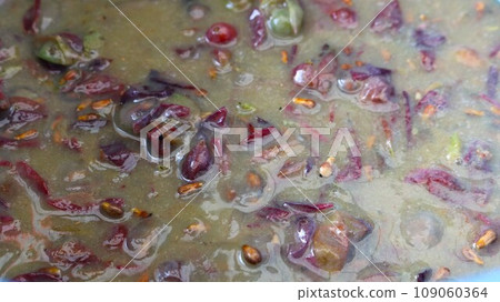 close-up of grape must in the fermentation stage interspersed with seeds and cake, wet slurry of grape juice from whole berries for preparing wine, wine production at home 109060364