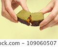 Woman's hands breaking vegan chocolate bar with dried fruits 109060507