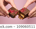 Woman's hands breaking vegan chocolate bar with dried fruits 109060511