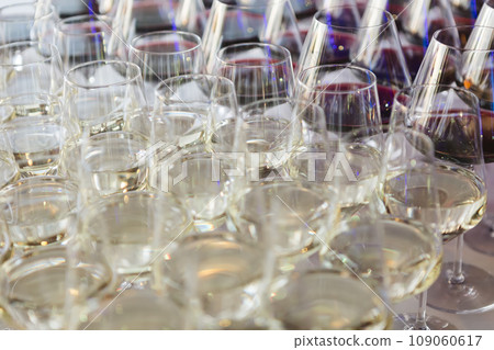 Glasses with white wine. Catering services. Glasses with wine in row background at restaurant party. Shallow dof Glasses with white wine. Catering services. Glasses with wine in row background at restaurant party. Shallow dof 109060617