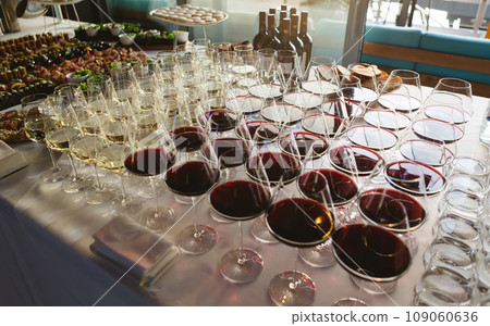 Glasses with white and red wine. Catering services. Glasses with wine in row background at restaurant party. Shallow dof Glasses with white and red wine. Catering services. Glasses with wine in row background at restaurant party. Shallow dof 109060636