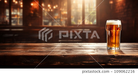 chilled beer in a glass glass on a wooden tabletop against a blurred bar background 109062216