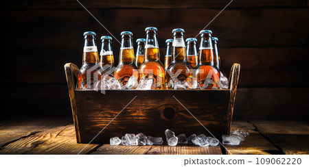 glass bottles with beer and ice in a wooden box glass bottles with beer and ice in a wooden box 109062220