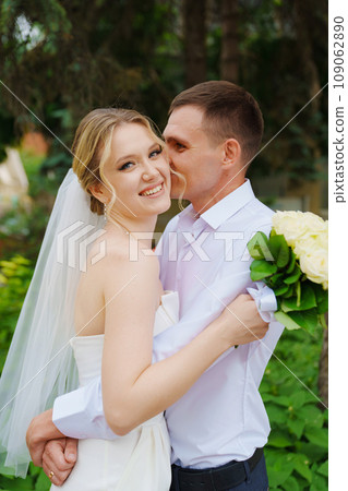 Gentle and happy newlyweds on a walk in the park. Gentle and happy newlyweds on a walk in the park. 109062890
