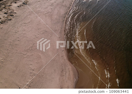 Drone aerial view of waves sea ocean coast. Beach and dunes dark calm sea waves nature landscape captured with drone. Tourism 109063441