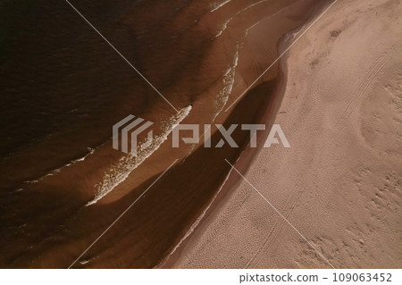 Drone aerial view of waves sea ocean coast. Beach and dunes dark calm sea waves nature landscape captured with drone. Tourism 109063452