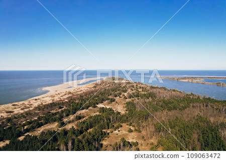 Aerial view drone of river goes into the sea. Delta of Vistula river goes in Baltic Sea in Sobieszewo Gdansk Poland. Forest and small village around 109063472