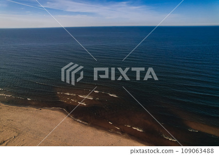 Drone aerial view of waves sea ocean coast. Beach and dunes dark calm sea waves nature landscape captured with drone. Tourism 109063488