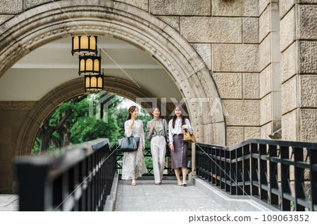 Woman walking with friends in a fashionable building Woman walking with friends in a fashionable building 109063852