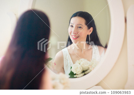 Young Asian woman looking in the mirror. 109063983